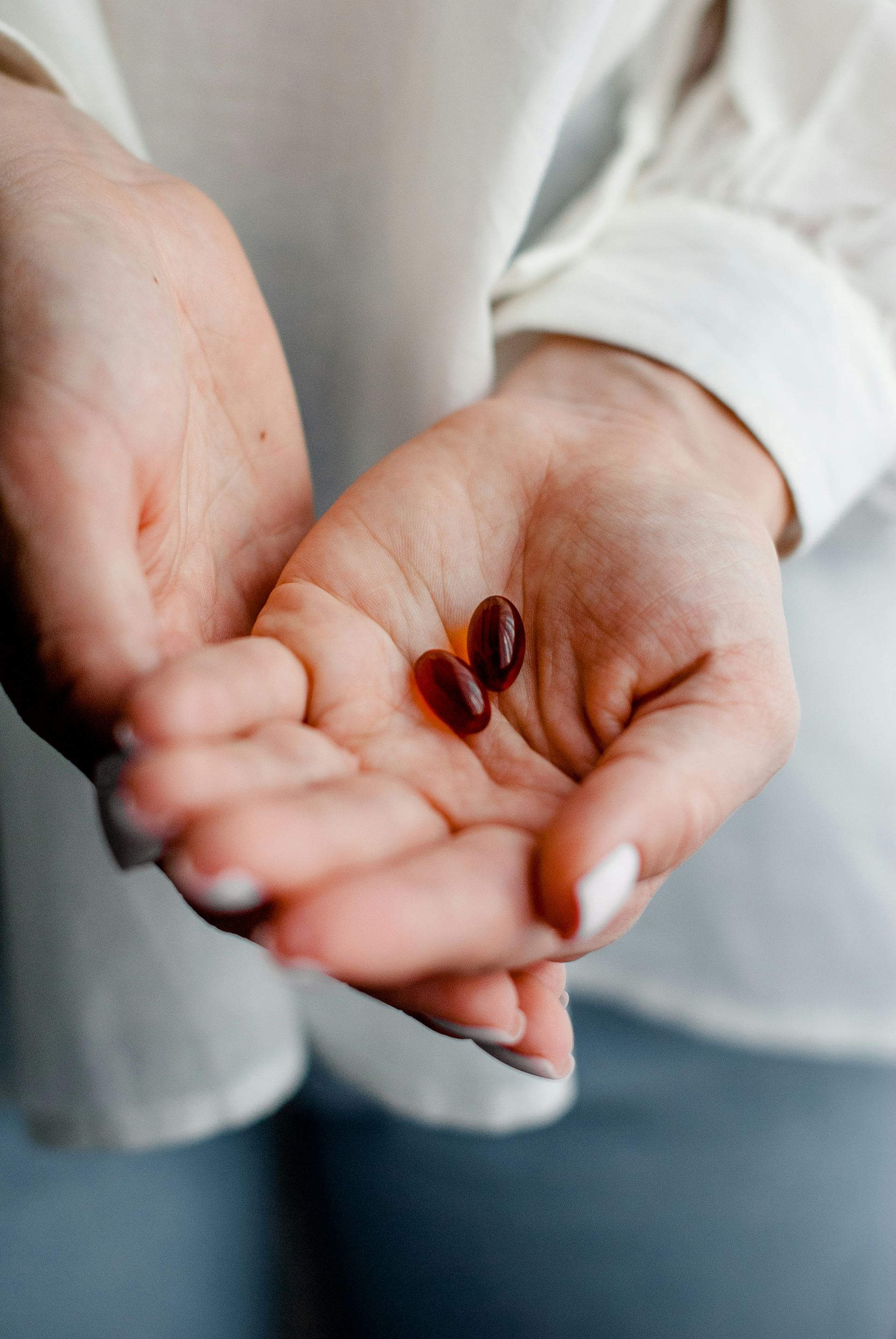 a hand holding a pill